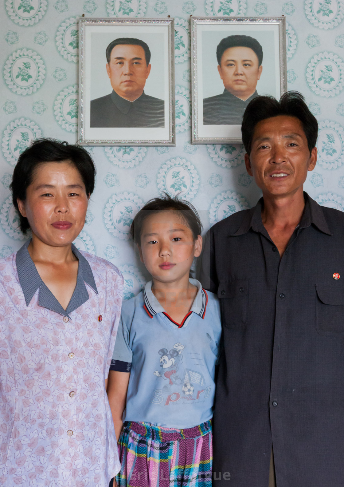 North Korean  family  in front of the portraits of the Dear 